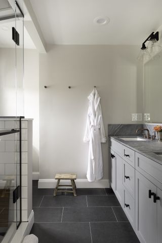 farmhouse shower with grey cabinets and slate floor