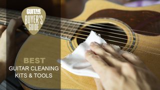 Person wiping an acoustic guitar with a cloth