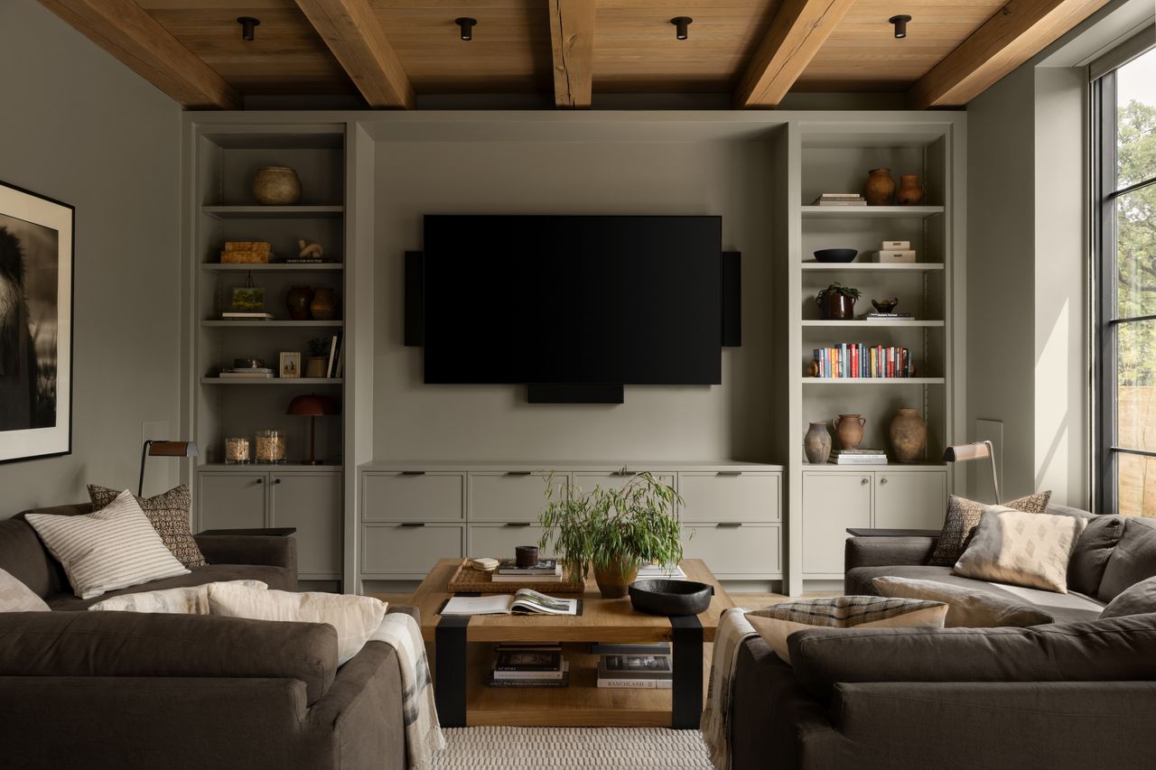 A family room with two L-shaped sofa on either side of the TV
