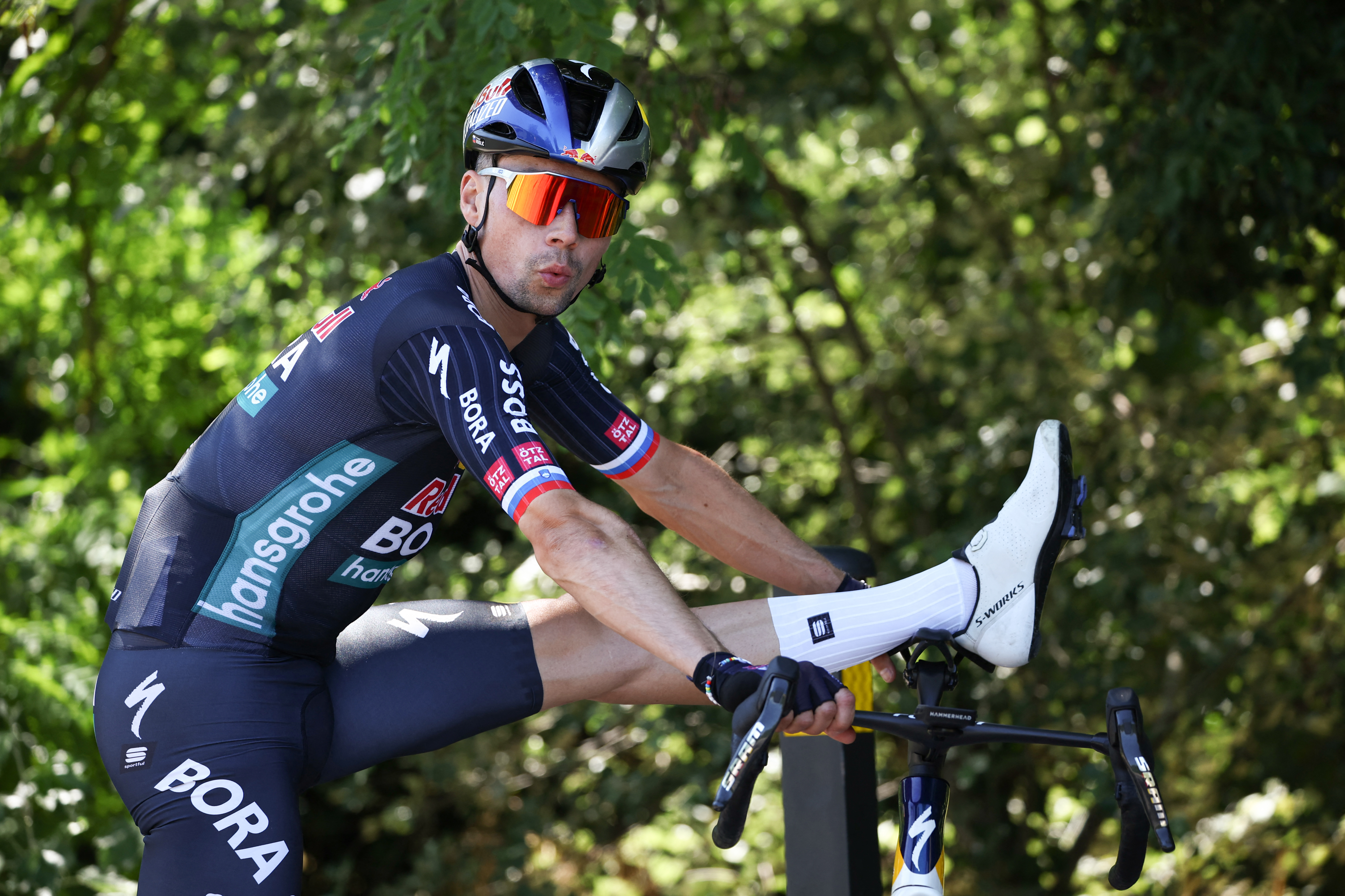 Red Bull - BORA - hansgrohe team&#039;s Slovenian rider Primoz Roglic stretches before taking part in a team training session on the eve of the start of 111th edition of the Tour de France cycling race, in Florence in Italy, on June 28, 2024. (Photo by Anne-Christine POUJOULAT / AFP)