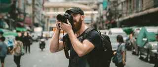 Photographer taking a photo on a busy city street