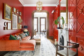 A photo of a glossy red living room with a red-orange couch