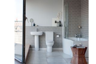 bathroom suite in a modern bathroom with sage metro tiles