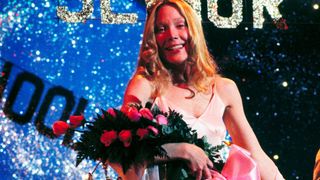 Sissy Spacek as Carrie, in a prom dress with flowers in Carrie
