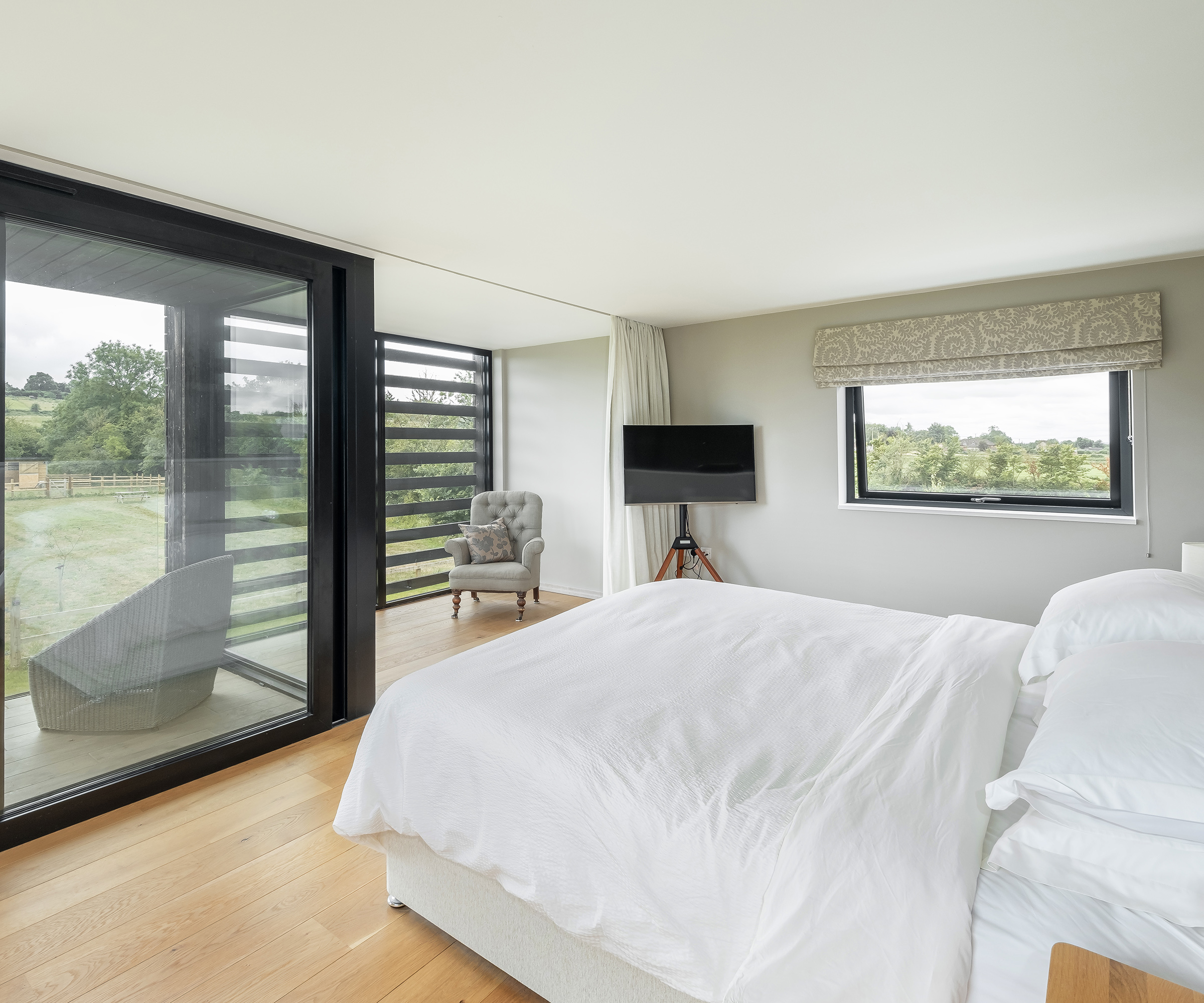 A bright and airy bedroom in a self build home with an outdoor terrace