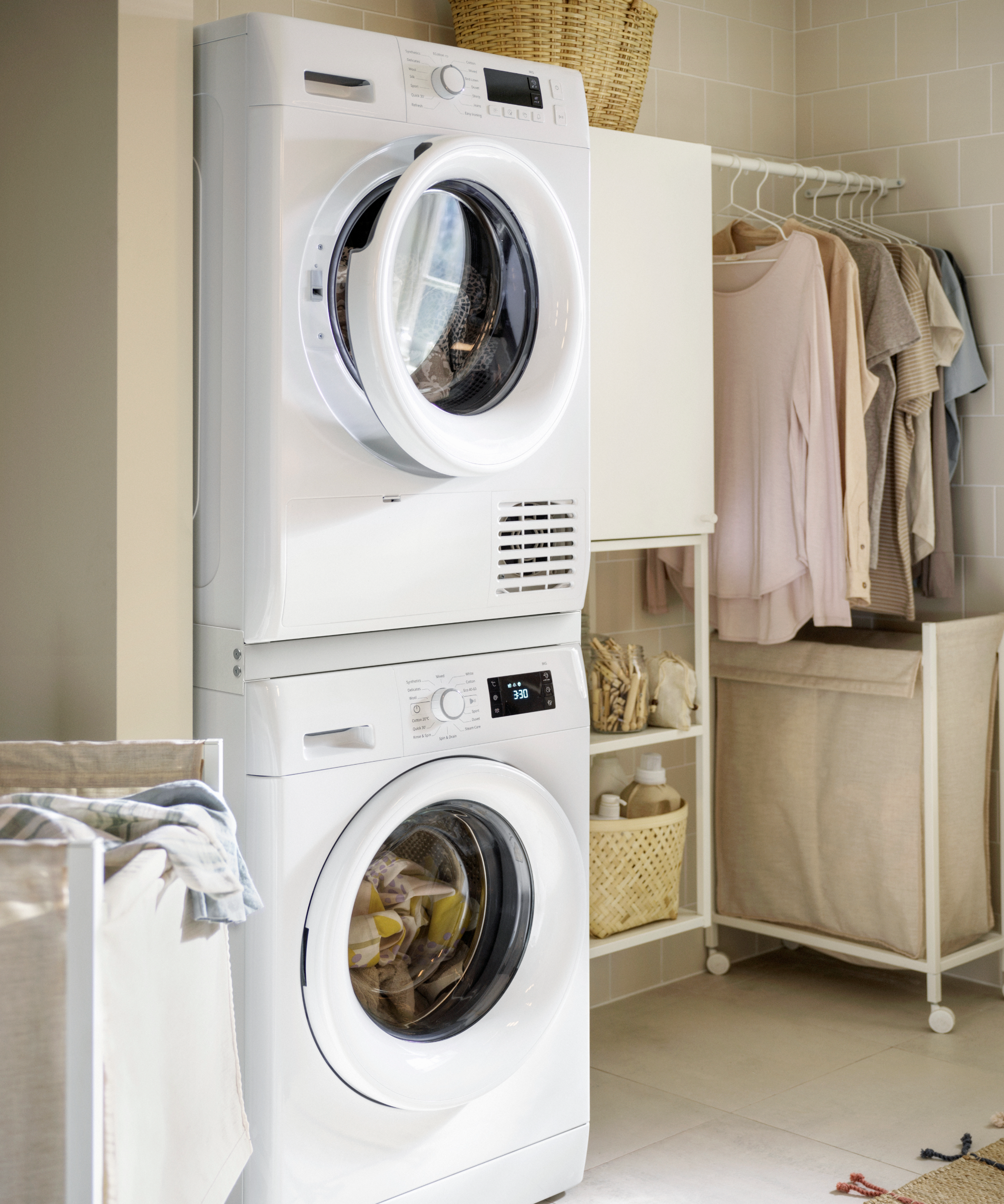 Ikea utility room with clothes and laundry basket in the corner next to a stacked tumble and washer