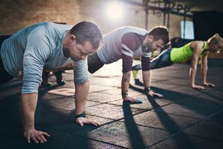 Men doing pushups at a gym.