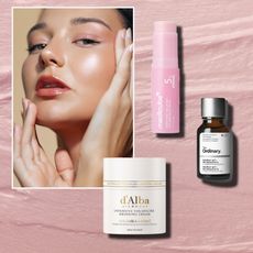 a white woman with glowing skin on a pink cream background next to a white jar of cream with gold writing, a pink tube of serum, and an amber jar with a white label