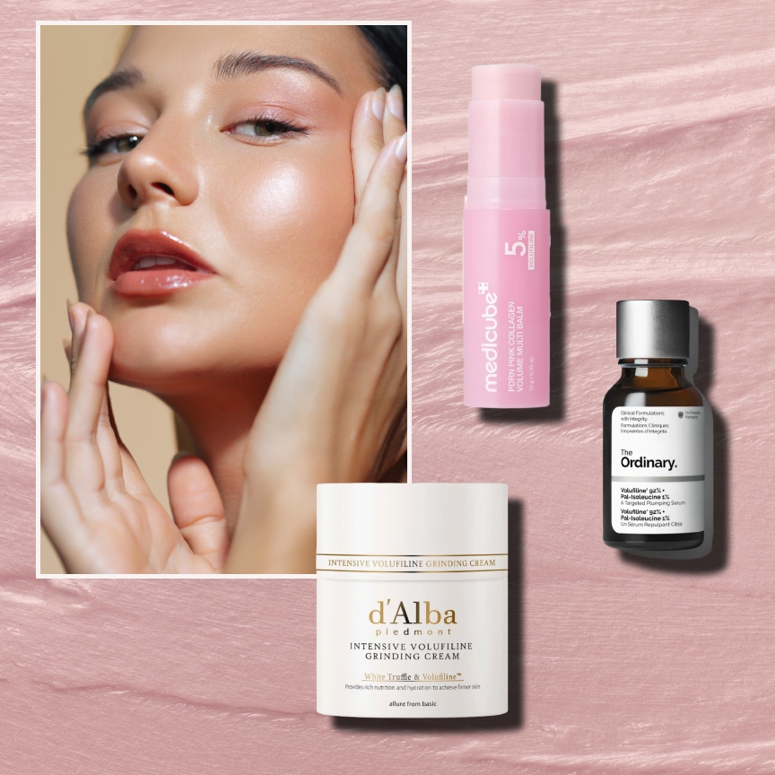 a white woman with glowing skin on a pink cream background next to a white jar of cream with gold writing, a pink tube of serum, and an amber jar with a white label
