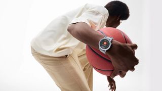 A man wearing the CMF by Nothing Watch Pro 2 while holding a basketball