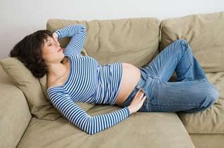 Pregnant woman asleep on the sofa