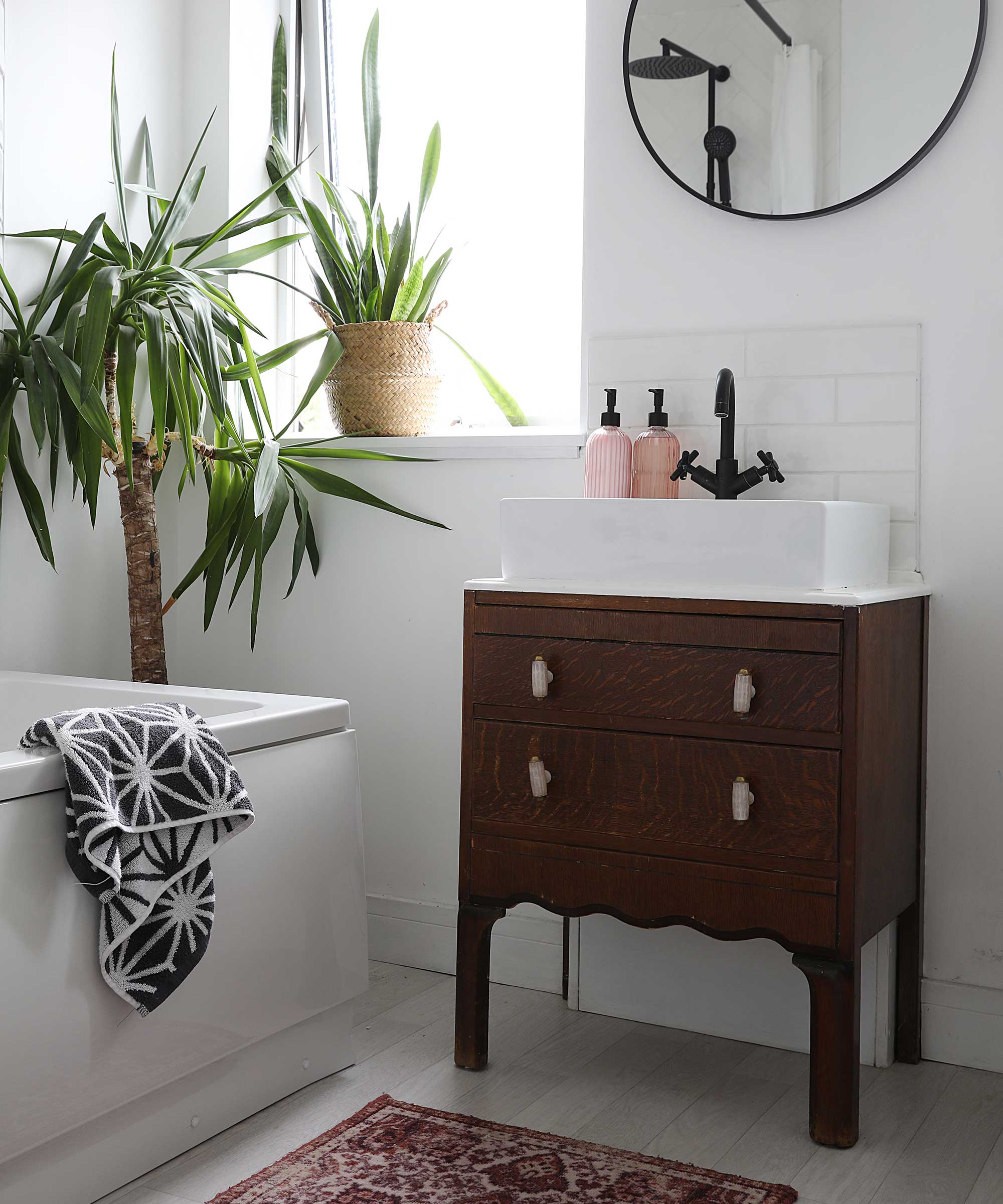 white bathroom with a vintage-style unit with a white basin and black tap on top