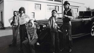 Fleetwood Mac posed by a vintage car