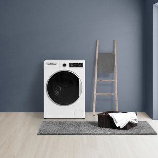 Navy wall behind white washing machine and step ladder