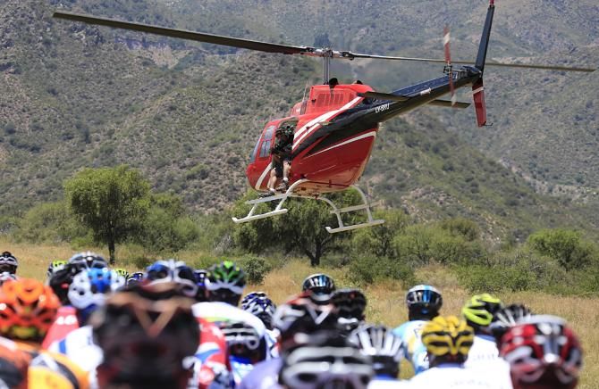 The television helicopter hovers low over the peloton.