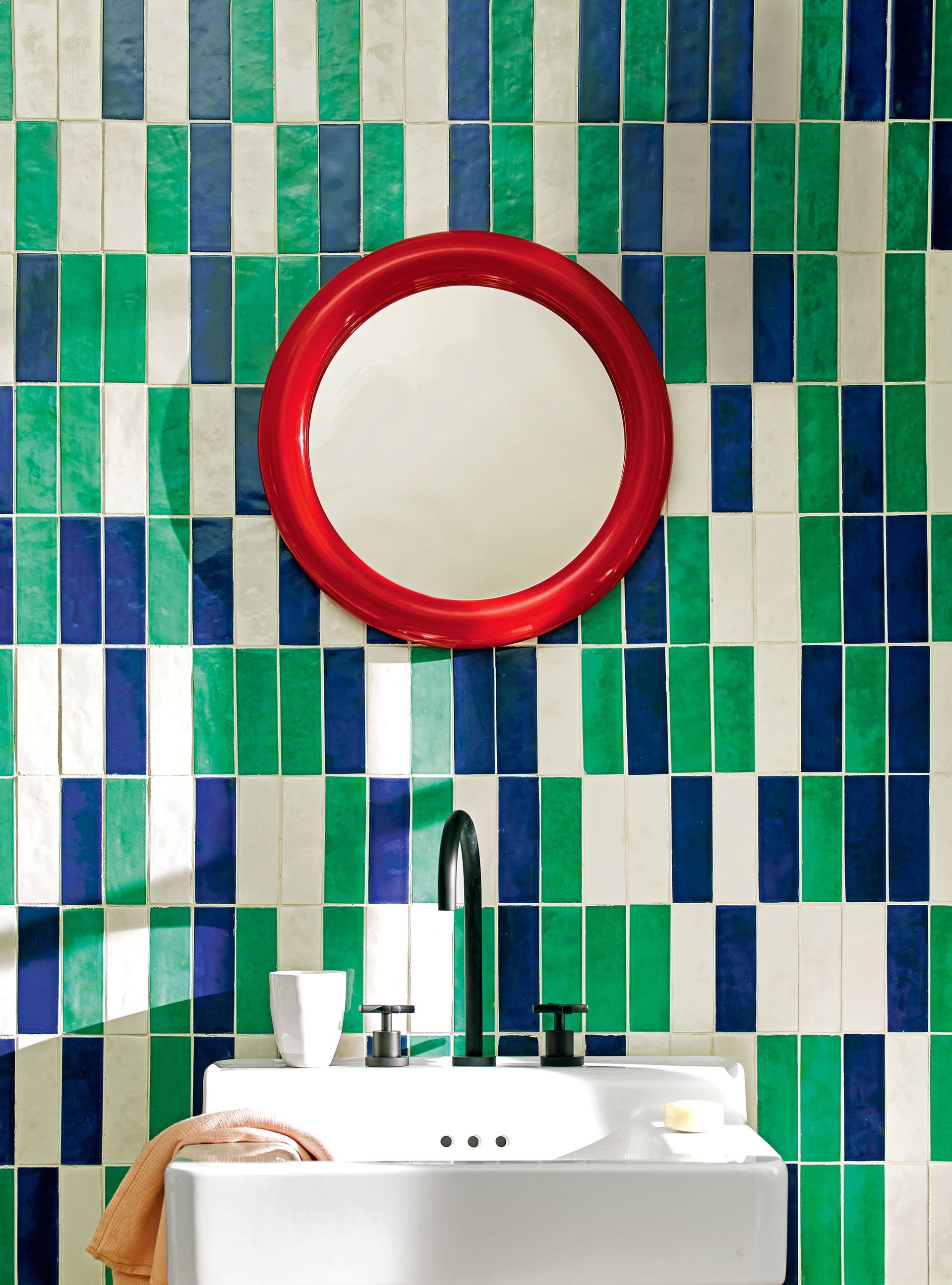 Bathroom color with green and blue tiles hung vertically on wall