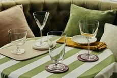 a selection of cocktail glasses on a striped green tablecloth