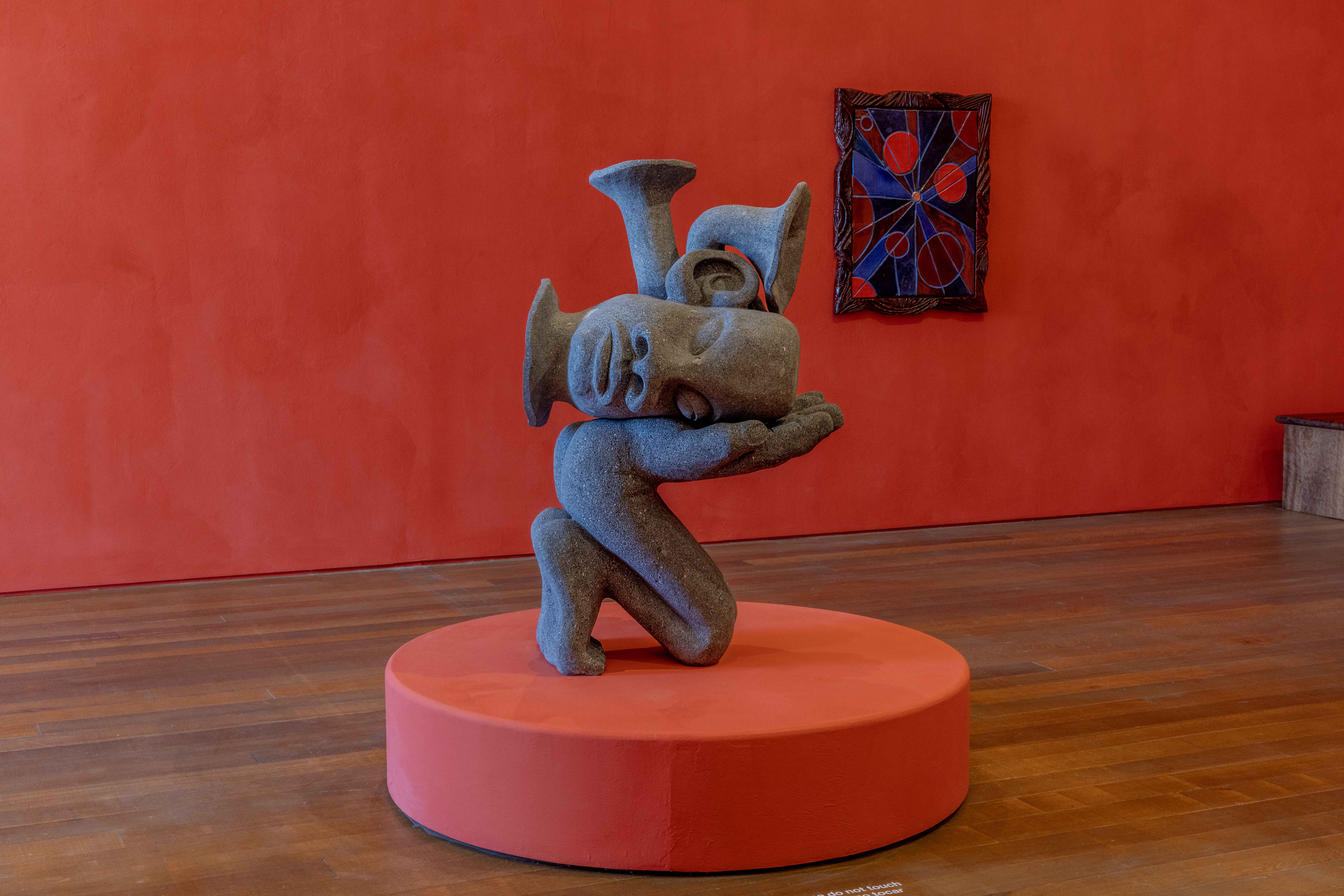 Woody De Othello sculpture on red background