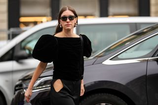 A woman wears a black velvet top.