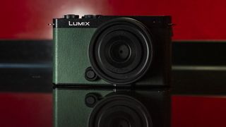 Appareil photo Panasonic Lumix S9 en couleur Olive foncé sur une surface rouge riche en reflets