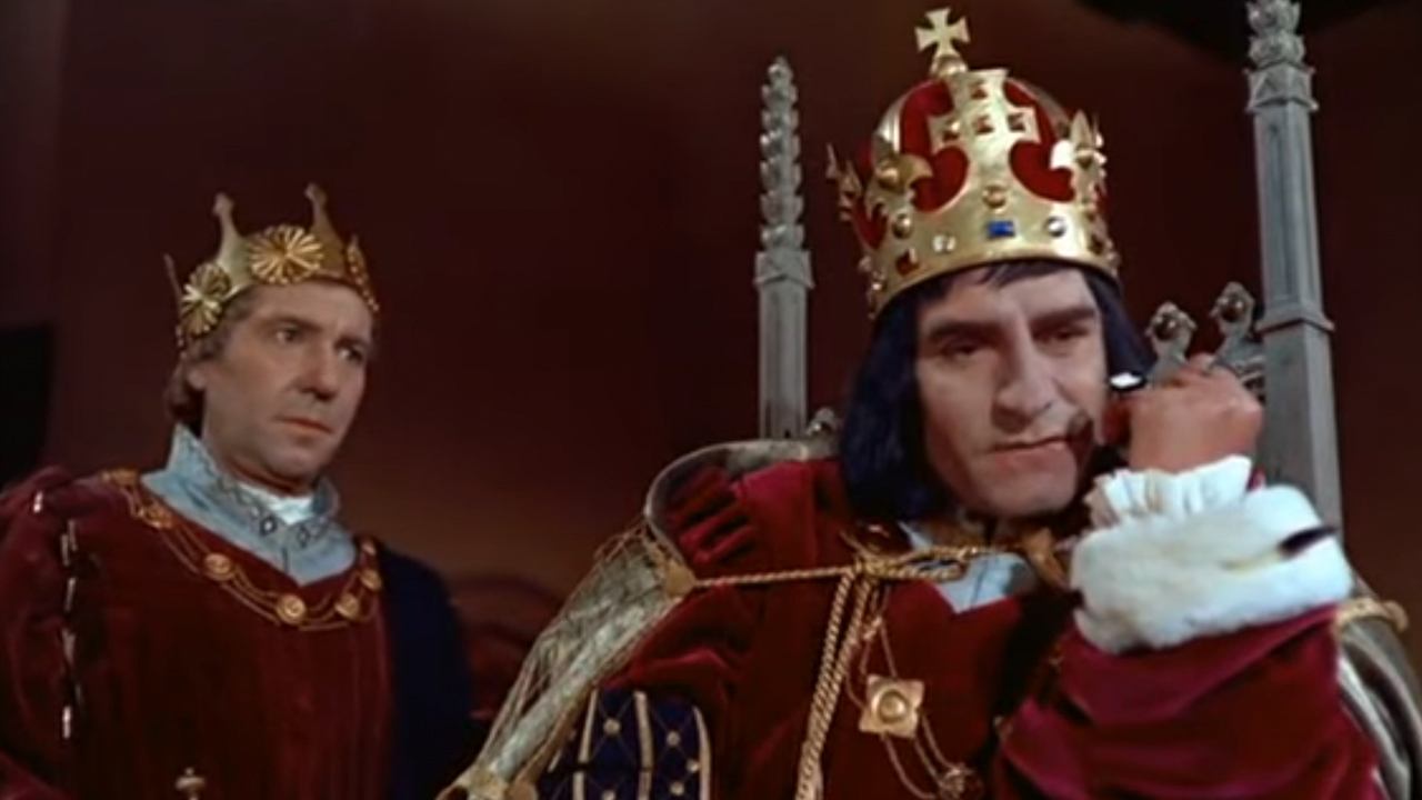 Sir Laurence Olivier sitting on a throne, wearing a crown in Richard III