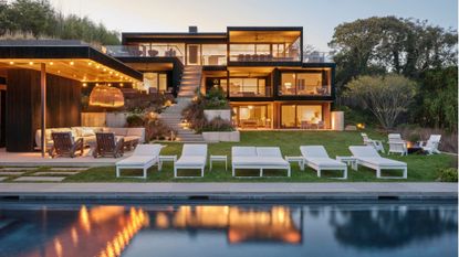 back exterior of home on multiple levels with glass walls and pool