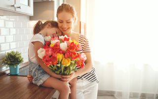 mother and daughter holding a colourful bouquet of flowers
