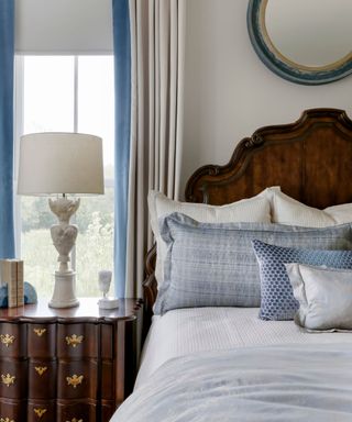 Blue and white bedroom with dark wooden headboard