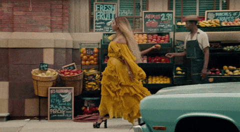 Beyonce walking past a vegetable stall
