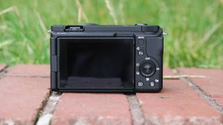 Sony ZV-E10 II digital camera from behind sitting on a brick wall