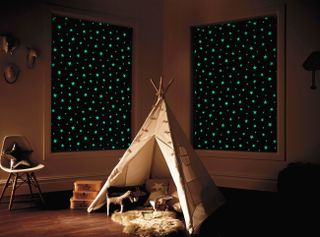 A children's bedroom themed like a campfire scene with a bespoke teepee bed and drawn window blackout blinds featuring glow in the dark stars
