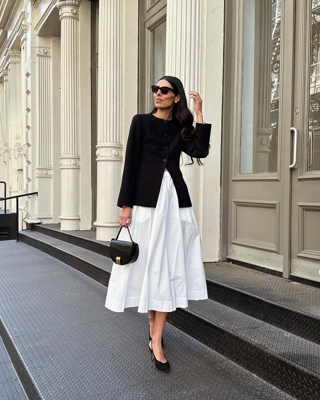 @babba wearing a white voluminous skirt and fitted black blazer
