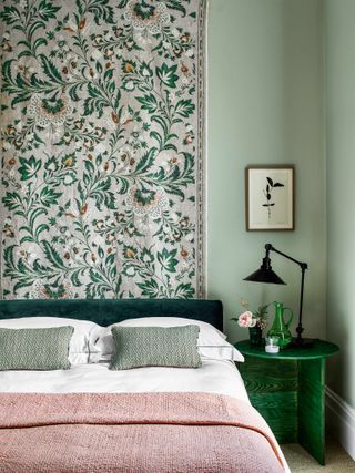 Pale green bedroom with fabric wall hanging