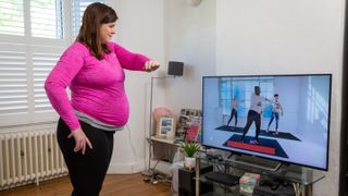 Woman following Couch to Fitness pregnancy workout on TV