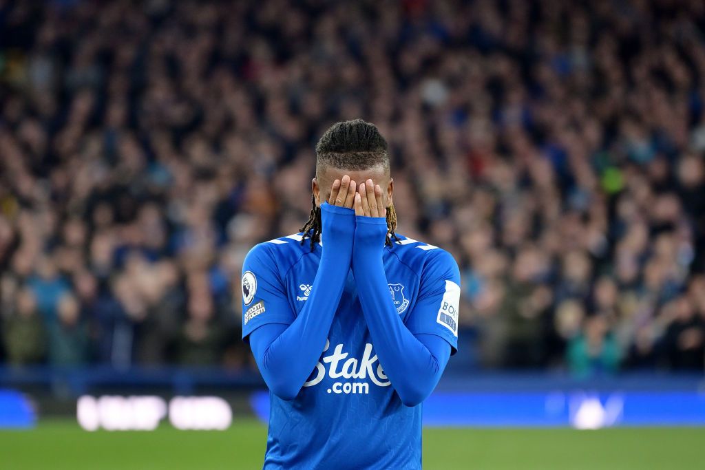 Everton's Alex Iwobi covers his face with his shirt.