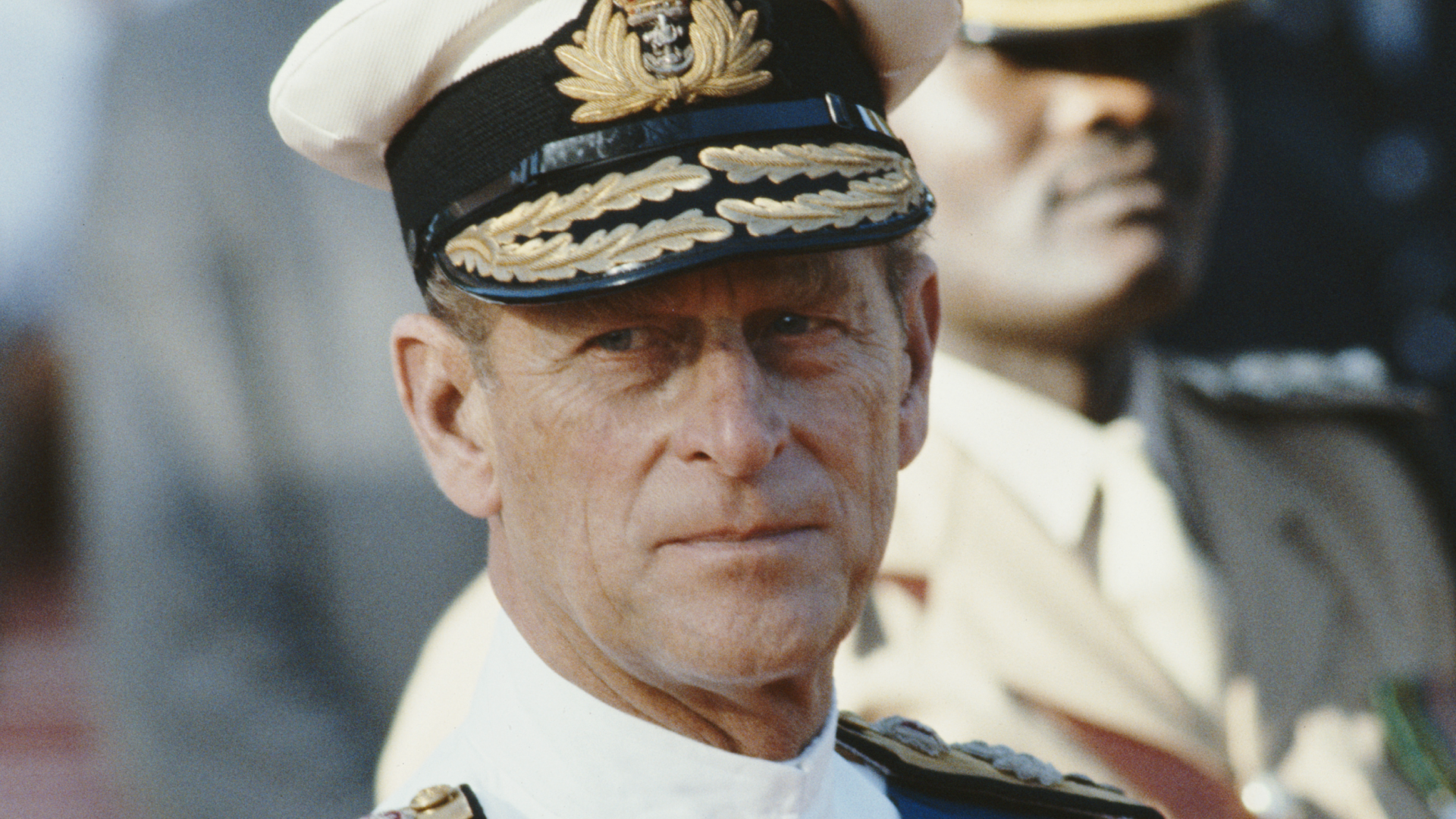 Prince Philip wears white naval uniform and looks stern