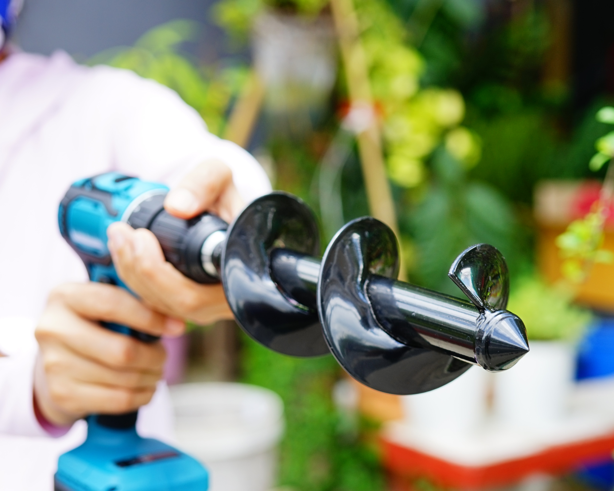 Brushless Power Drill in hand for drill soil for planting bulbs in garden at home