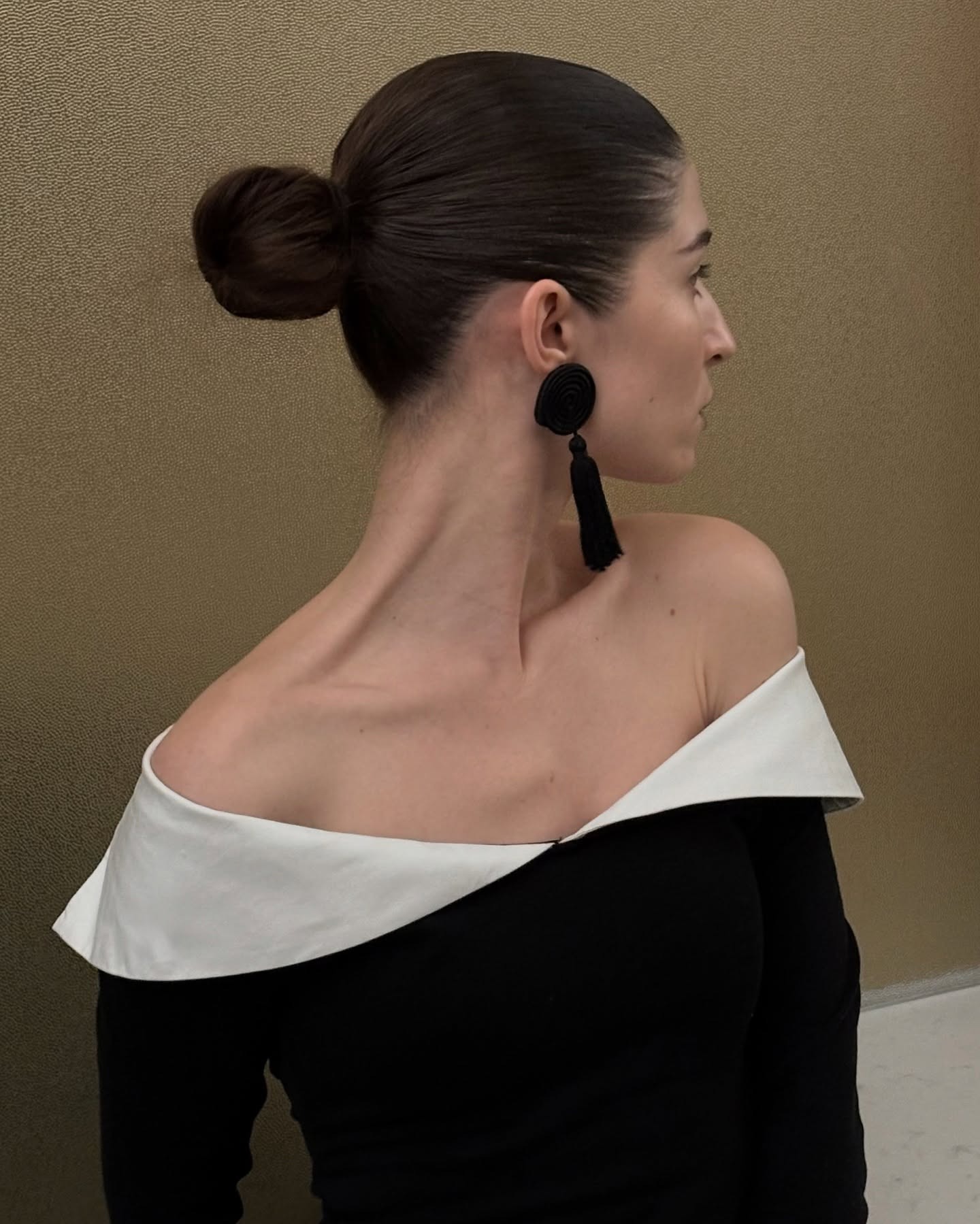 Woman wears black tassel earrings, which is one of the biggest jewelry trends of 2026.