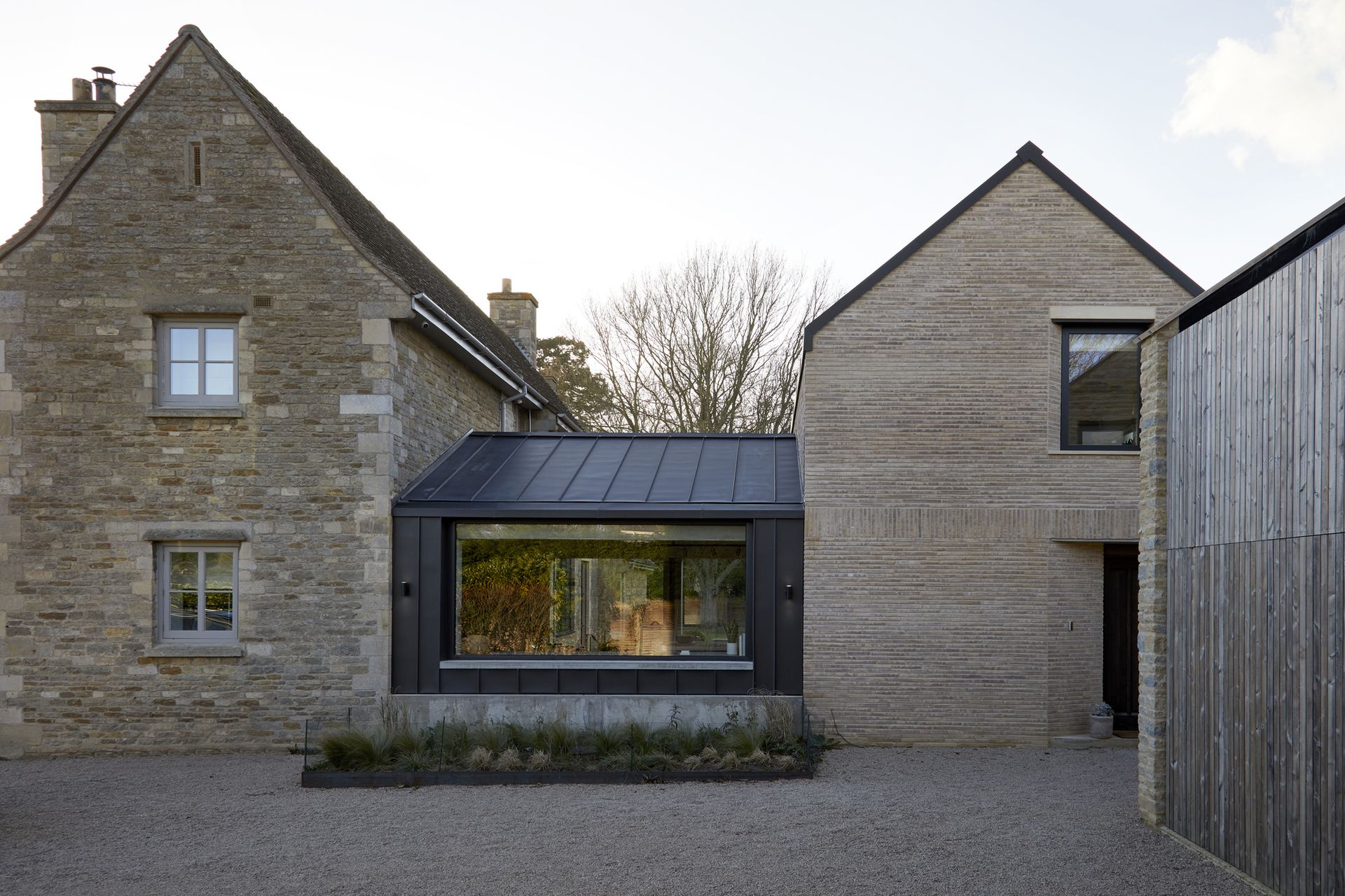 Large gray stone house with modern extension