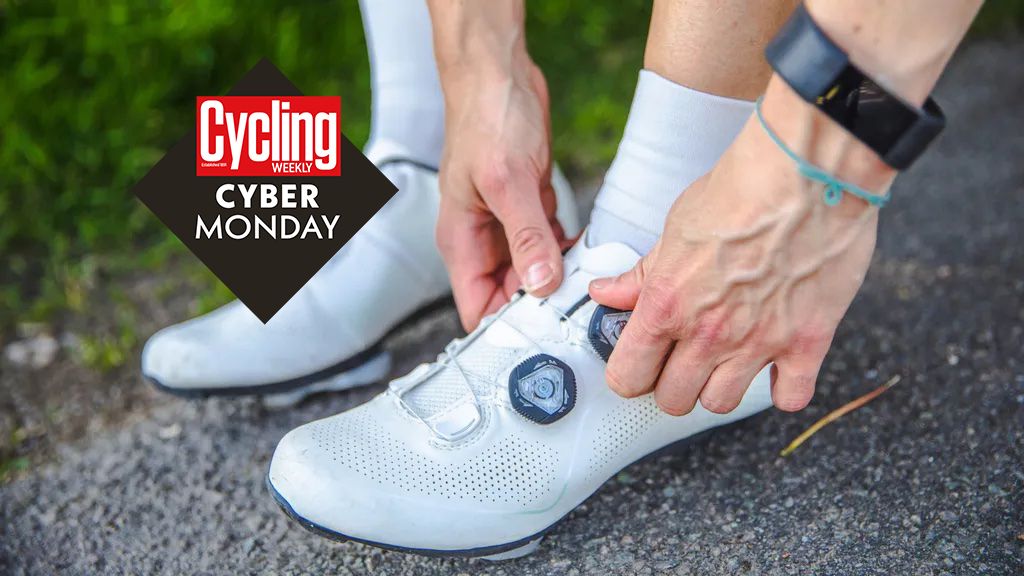 A cyclist puts on their white road cycling shoes