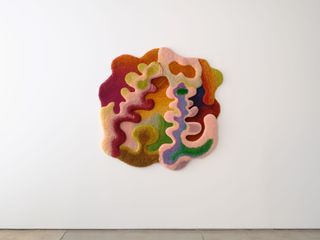 Colourful, irregularly shaped rug on wall