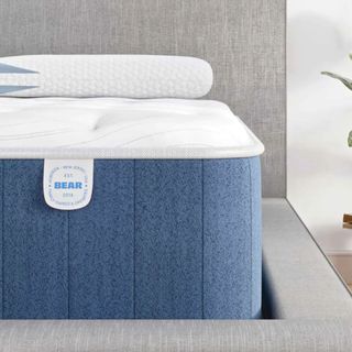 Corner of the Bear Elite Hybrid Mattress on a gray bed base.