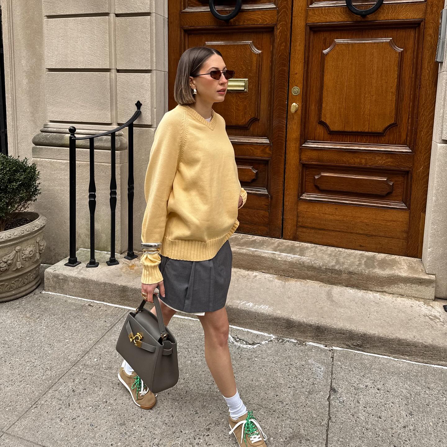 Tinsley Crisp wears V Neck + Mini Skirt + Trainers