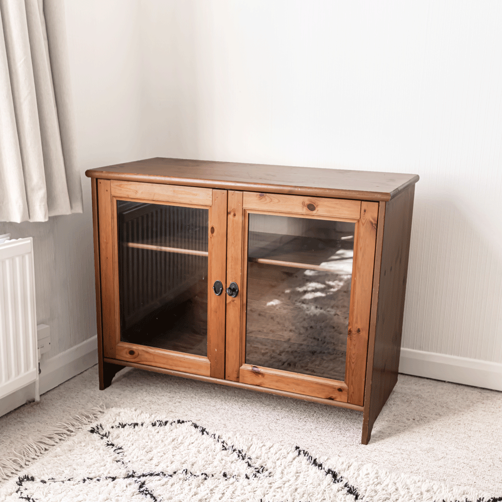 A wooden storage cabinet with glass doors