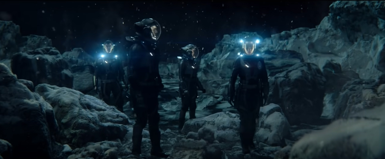four spacesuited astronauts explore an alien world at night.