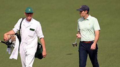 Michael McDermott and his caddie walk during the 2023 Masters