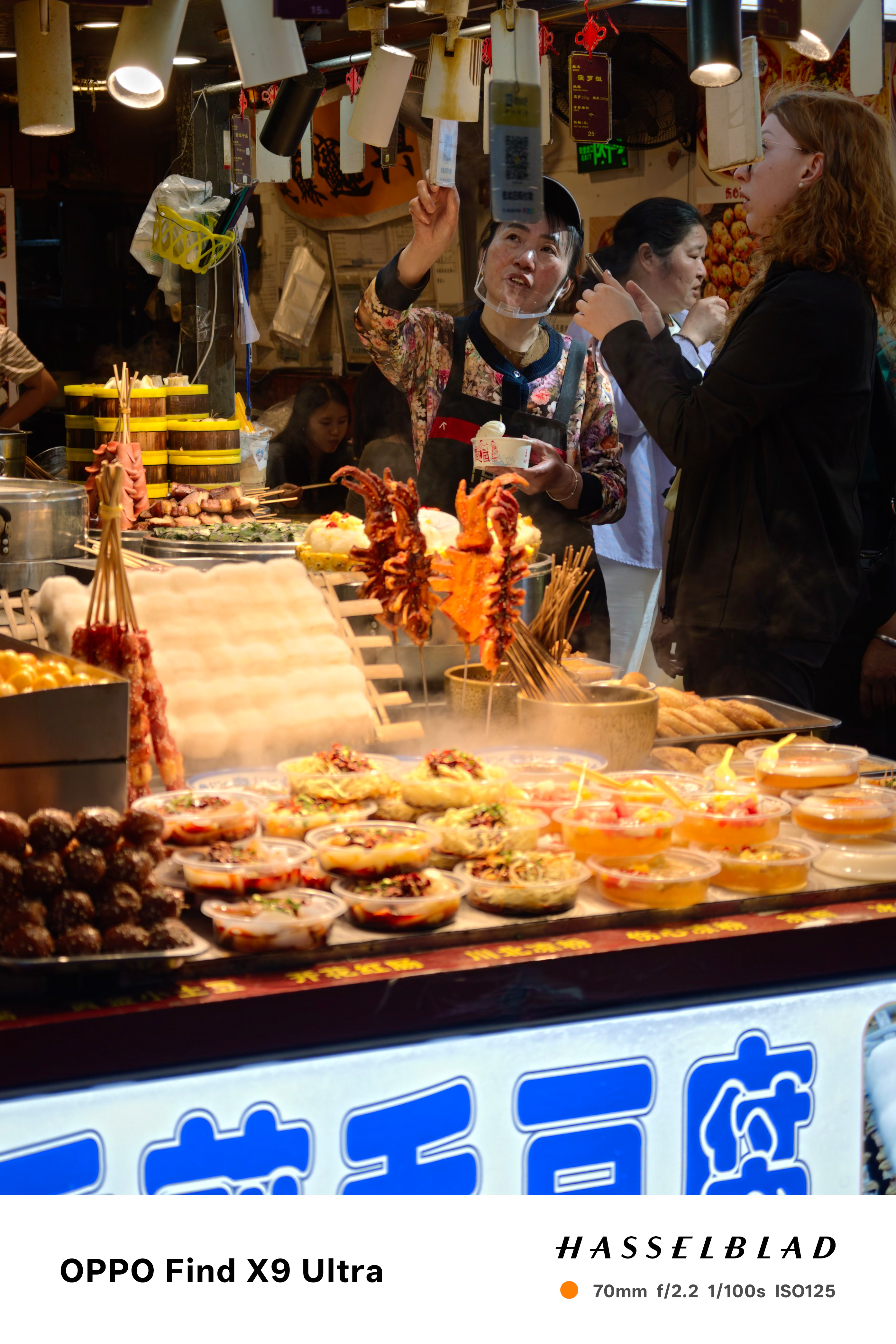 Busy food stall with steaming street snacks and customers ordering