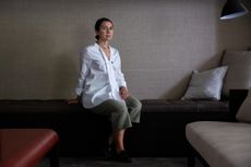 A portrait of Maria Porro, Salone del Mobile president, sitting on a upholstered bench