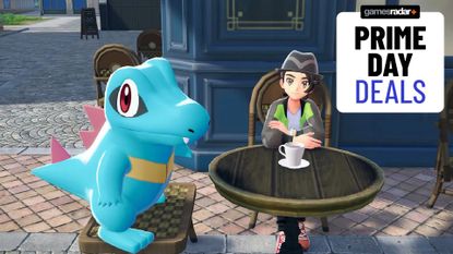 A Totodile and trainer look up from a table with a coffee cup, with a GamesRadar+ Prime Day deals badge in the top right-hand corner of the frame