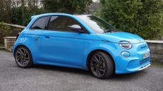 The Abarth 500e Turismo in Poison Blue, sat on a gravel driveway